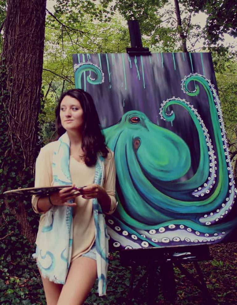 Nash standing outside with octopus painting on easel beside her